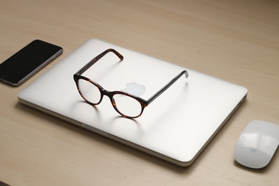 银色MacBook上的玳瑁框太阳镜